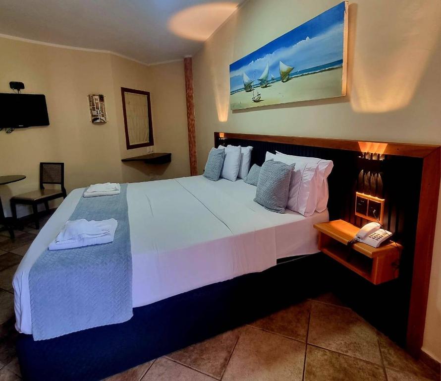 a hotel room with a large bed and a phone at IL Nuraghe in Canoa Quebrada