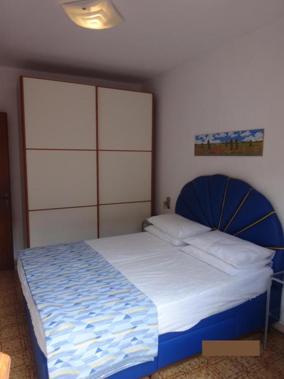 una camera con un grande letto con testiera blu di Eraclea Mare a Eraclea Mare