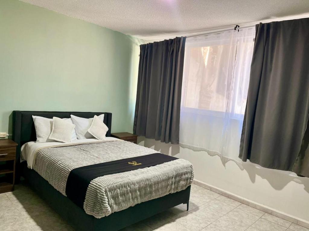 a bedroom with a bed and a large window at 8 VENATOR House Boutique in León