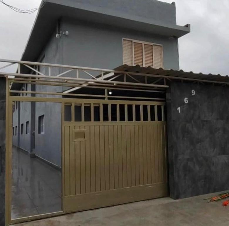 a house with a wooden garage door in front of it at Itu Loft Pousada Girassol in Itu