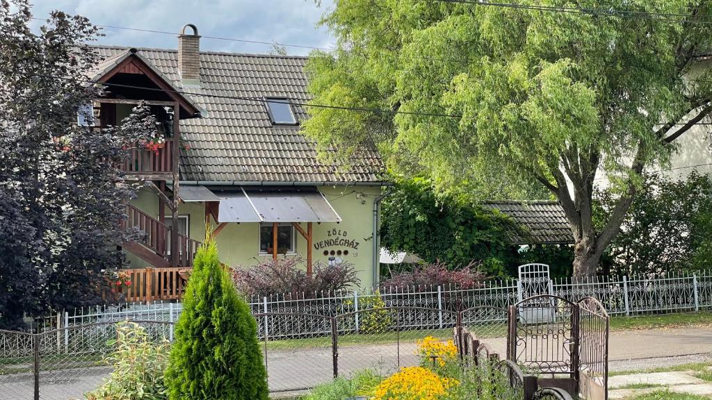 a house with a fence in front of it at Zöld Vendégház in Csernely
