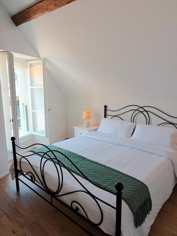 a bedroom with a bed with a green and white blanket at Zogbi Hospitality Aubonne 3 in Aubonne