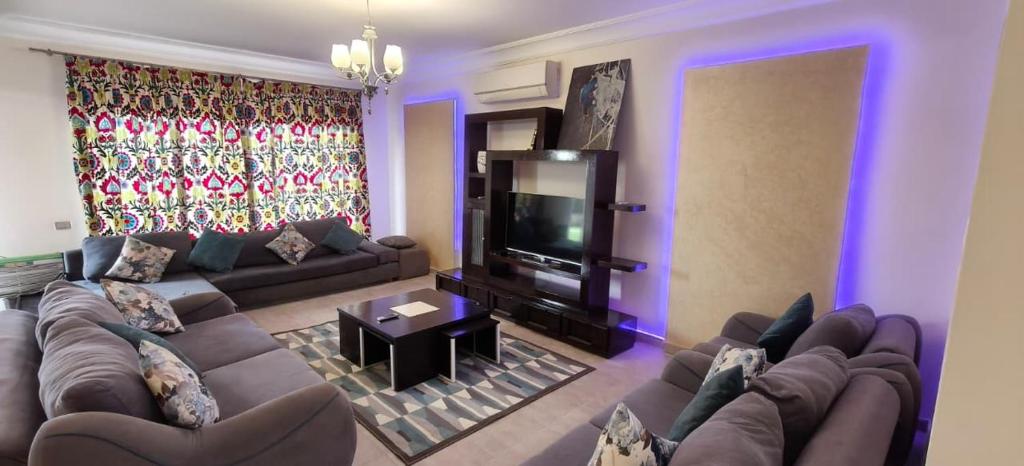 a living room with a couch and a television at El Ain El Sokhna-Villa at Piacera Resort Seaview in Ain Sokhna