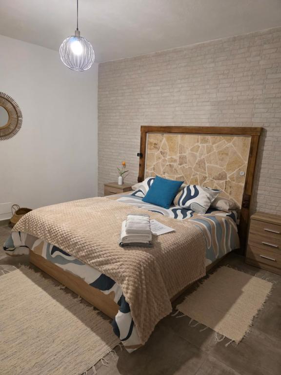 a bedroom with a large bed and a brick wall at 25 Atardeceres in El Paso