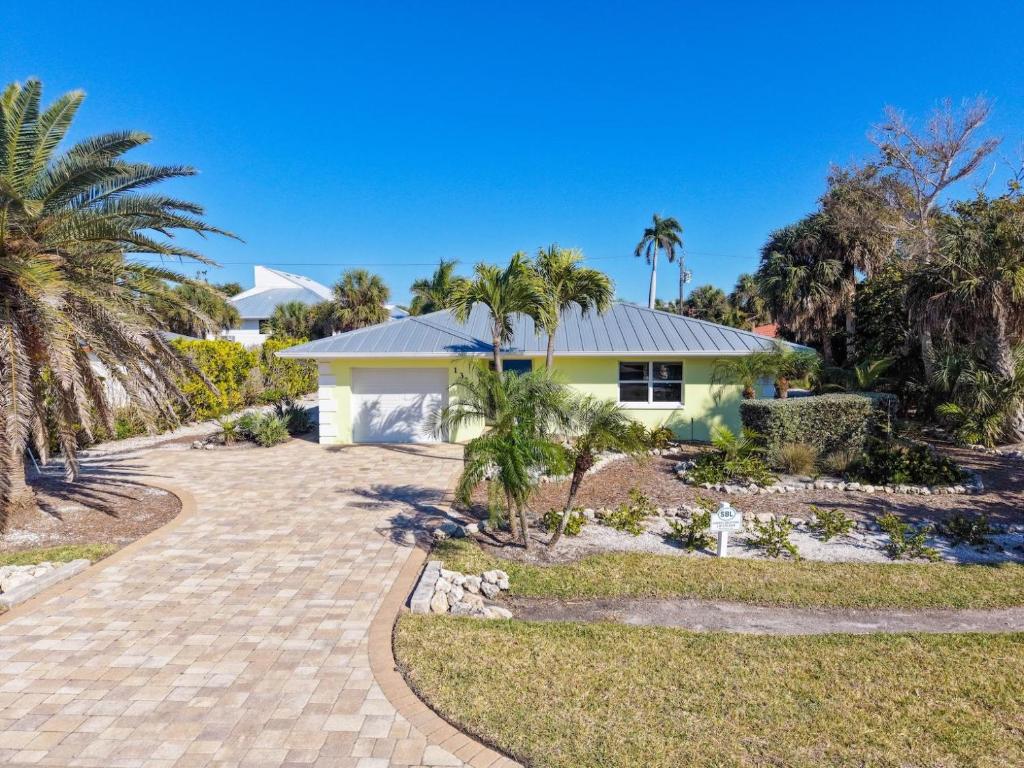 a house with palm trees and a driveway at Tahitian Waters in Sanibel