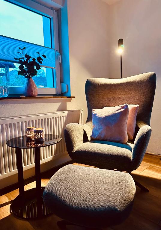 a living room with a chair and a table and a window at Ferienhaus Griede mit 3 Schlafzimmern in Mörsdorf