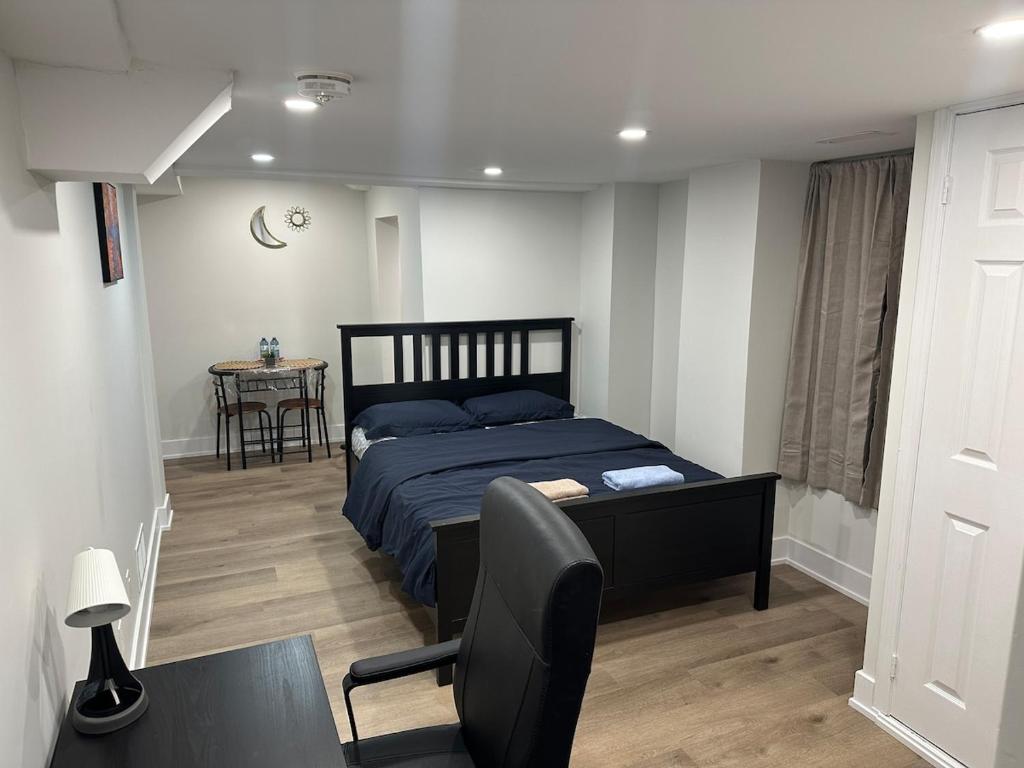 a bedroom with a bed and a table and a chair at Cozy Basement Studio with Private Bathroom and Kitchen in Vaughan