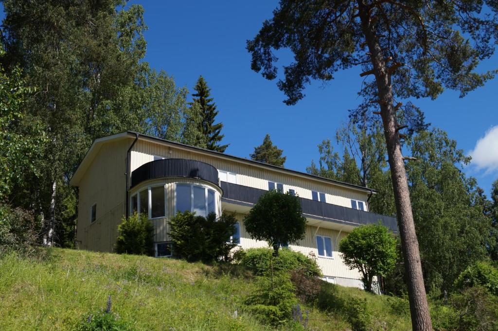 a house on top of a hill with trees at North Inn B&B in Sollefteå