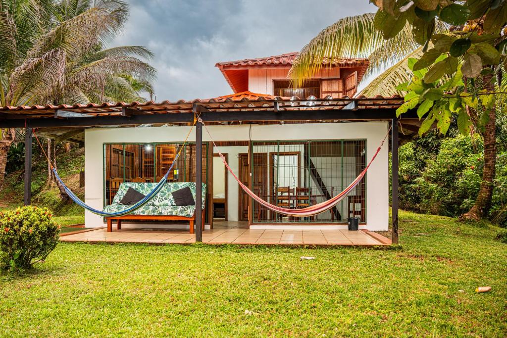 a house with a porch with a swing at Corcovado Green Cabin & House in Drake