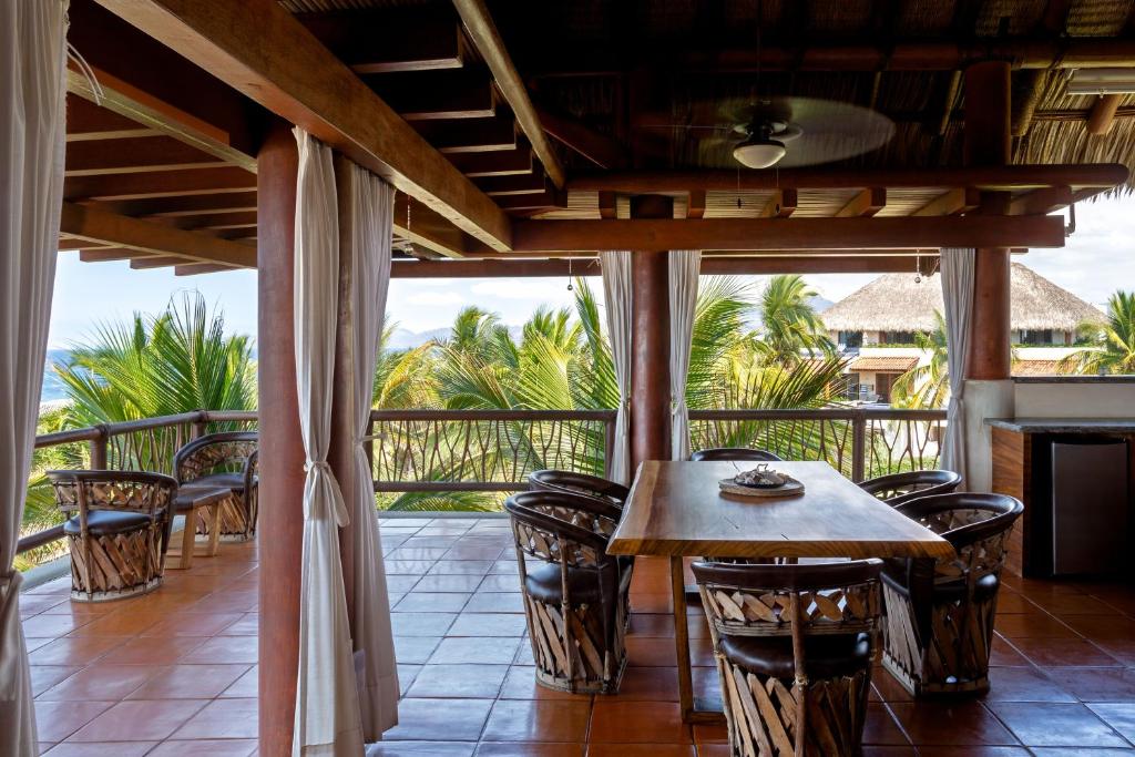 a patio with a table and chairs on a balcony at Stunning, Oceanfront Casa de Olas in Ixtapa-Zihuatanejo International