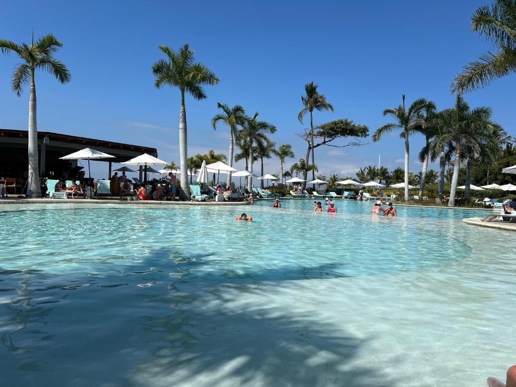 a large swimming pool with people in the water at luxury 2bed condo in Nuevo Vallarta