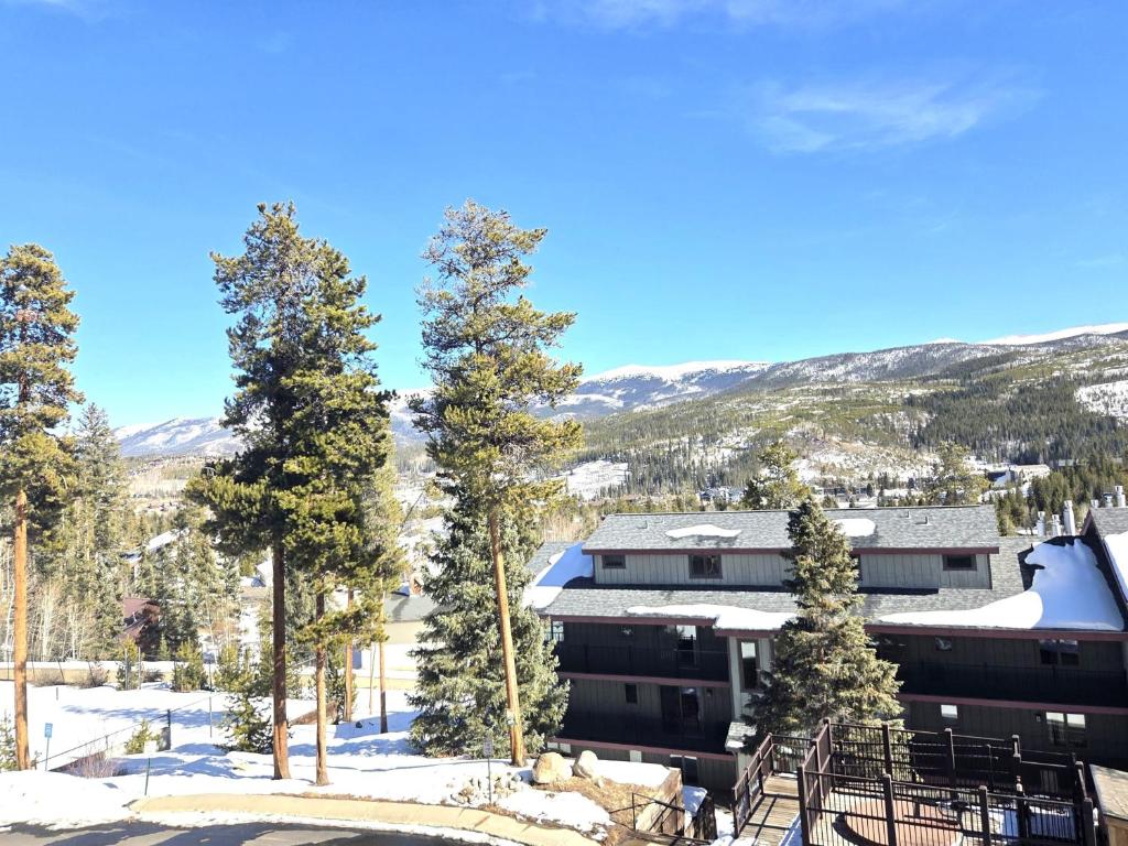 a view of a building in the snow with trees at Timber Run in Winter Park