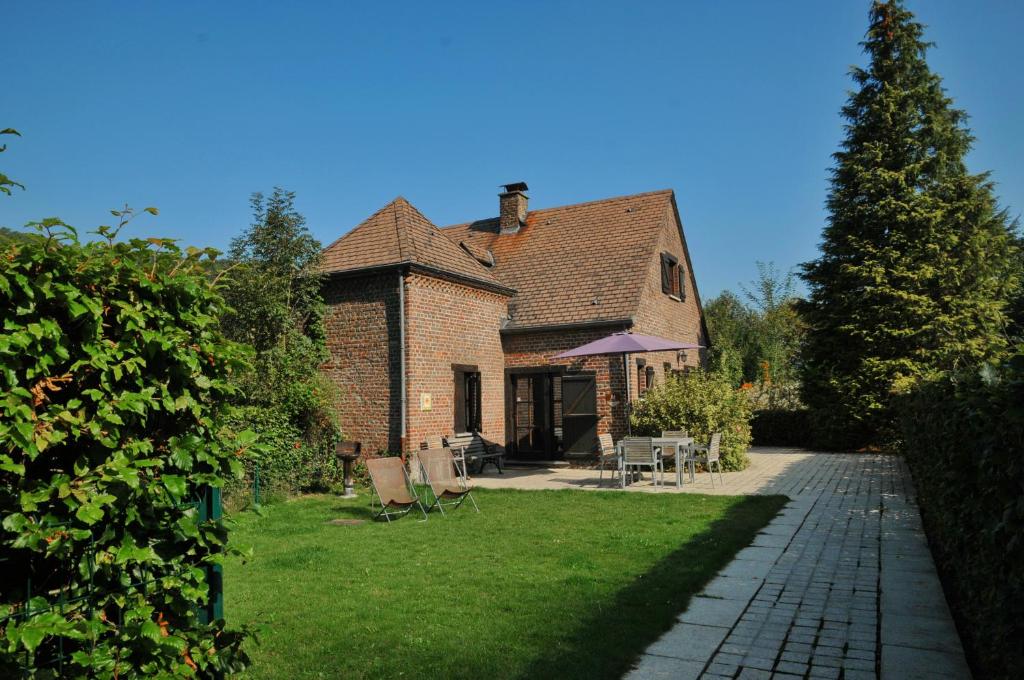 a brick house with a pathway leading to a yard at Holiday Home Poppenhuis in Durbuy