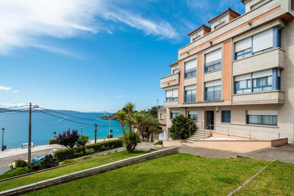 a building with a view of the water at Apartamentos Punta Lucero en Portonovo in Portonovo
