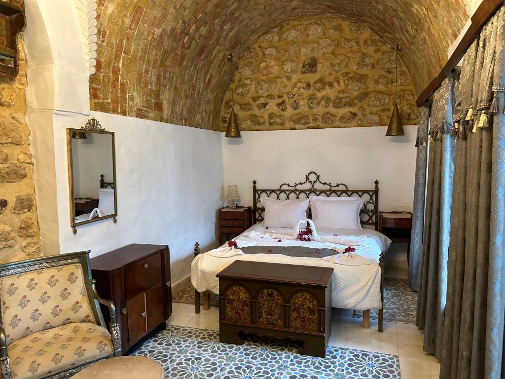 a bedroom with a bed and a chair at Guesthouse DarHamdoun in Ḩammām al Ghazzāz
