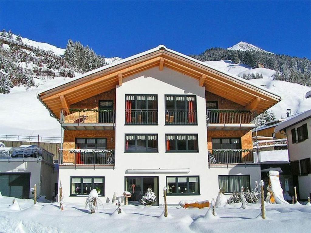 a large building in the snow with snow at Apartment Künzel by Interhome in Schröcken