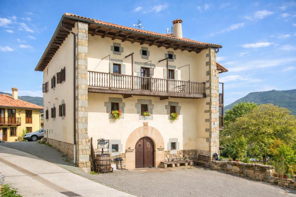 a large building with a balcony on top of it at Espacioso apartamento en el Pirineo Navarro in Saragüeta