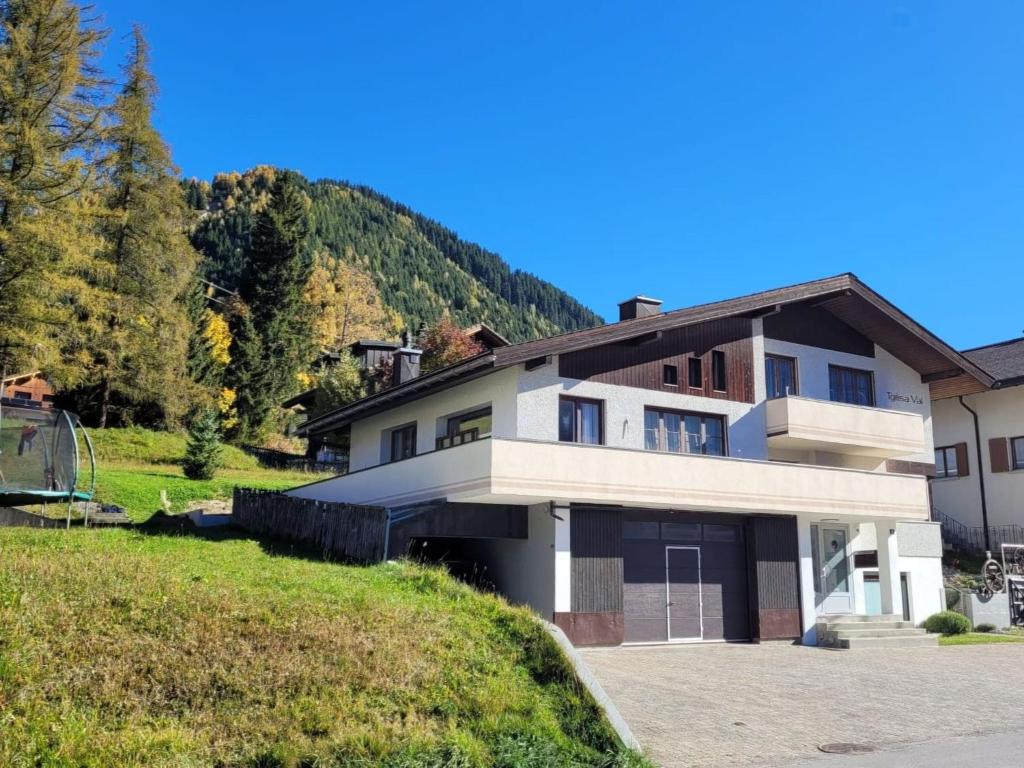 a large house with a hill in the background at Apartment Tgèsa Val by Interhome in Sedrun