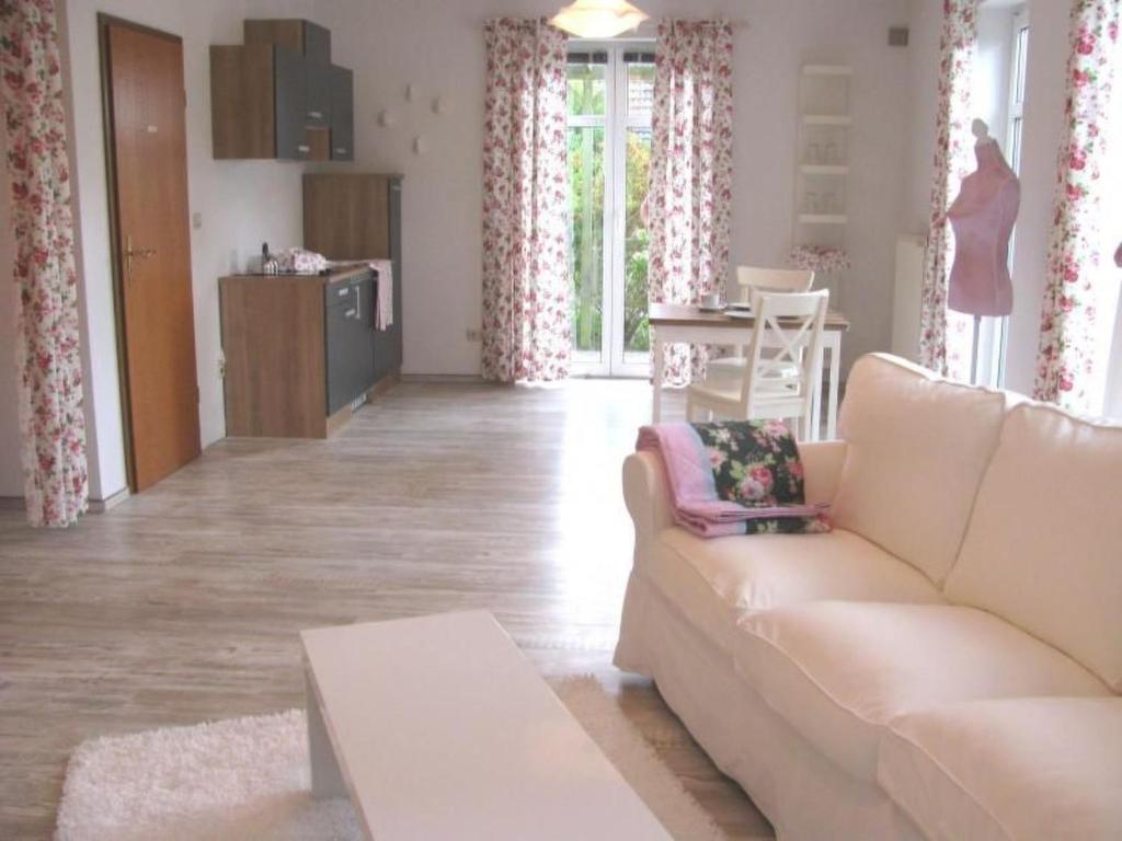a living room with a white couch and a kitchen at Apartment Florö by Interhome in Putbus