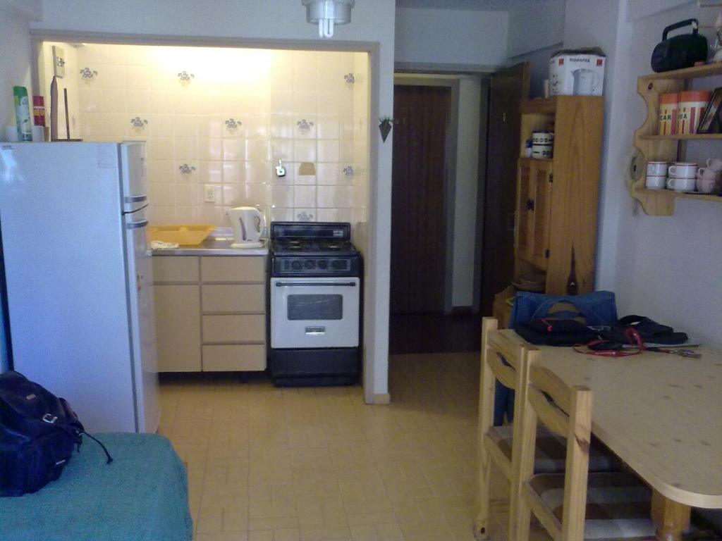 a kitchen with a stove and a table and a refrigerator at SAN CLEMENTE RIAZOr 6 in San Clemente del Tuyú