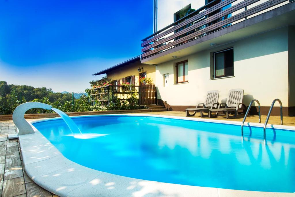 a swimming pool with a water slide in front of a house at Guesthouse Pavlin in Samobor