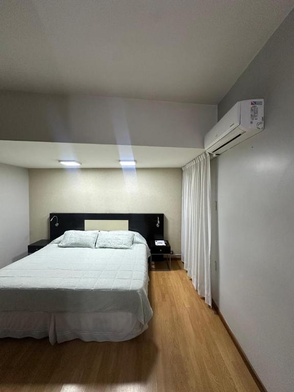 a bedroom with a white bed and a air conditioner at Urban II - Cómodo monoambiente en pleno centro in San Juan