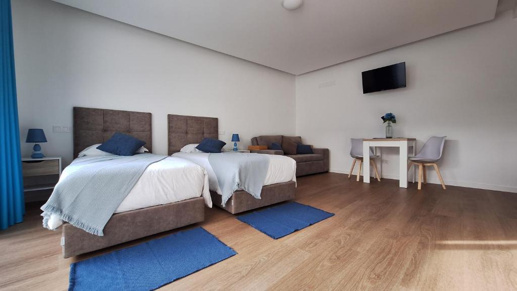 a bedroom with a large bed and a couch at AzoreanStar Accommodations in Ponta Delgada