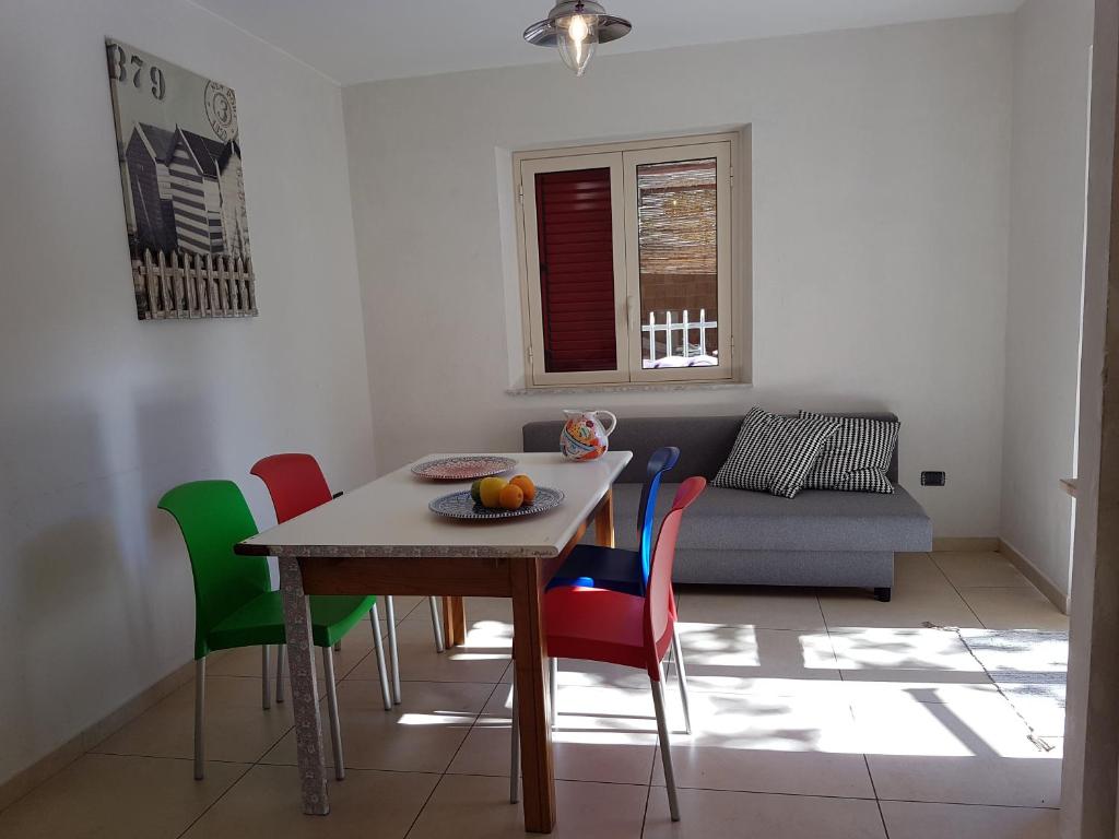 - un salon avec une table et des chaises colorées dans l'établissement Appartementi di Lu, à Marina di San Lorenzo