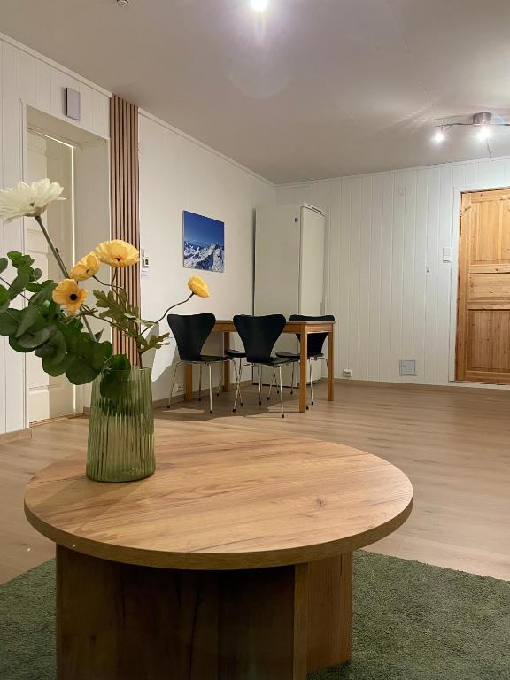 a room with a table with a vase of flowers on it at Modern apartment Kvaløya in Kvaloysletta