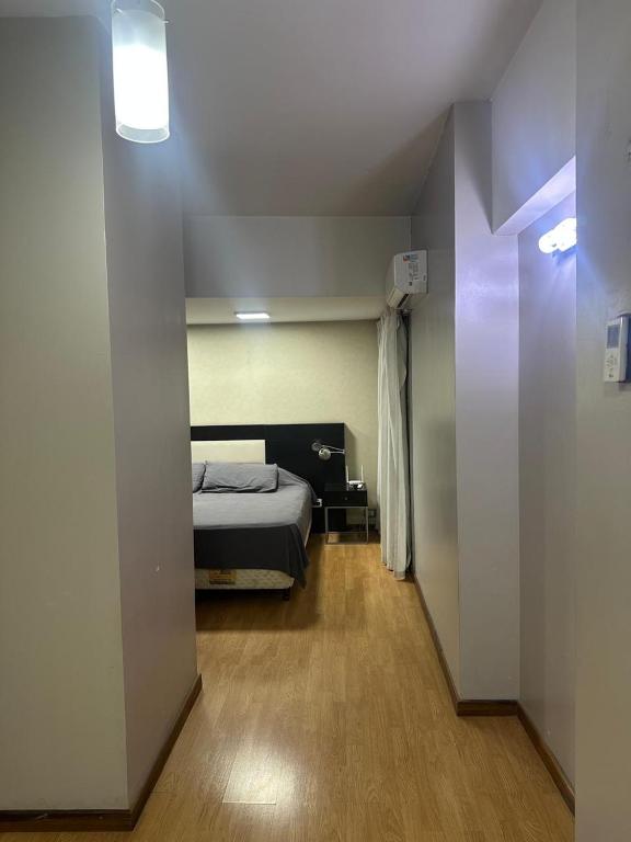 a bedroom with a bed in a room with a hallway at Urban III - Cómodo monoambiente en pleno centro in San Juan