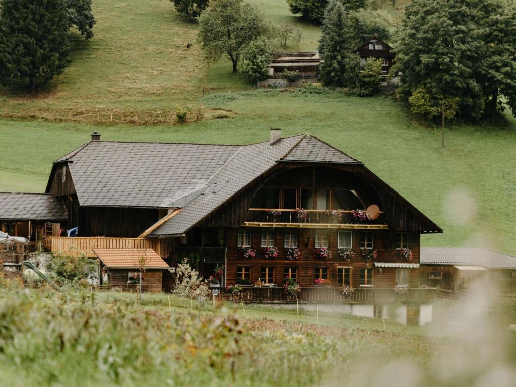 a large wooden house in a field at Apartment Hof Obertalgut by Interhome in Teuffenthal