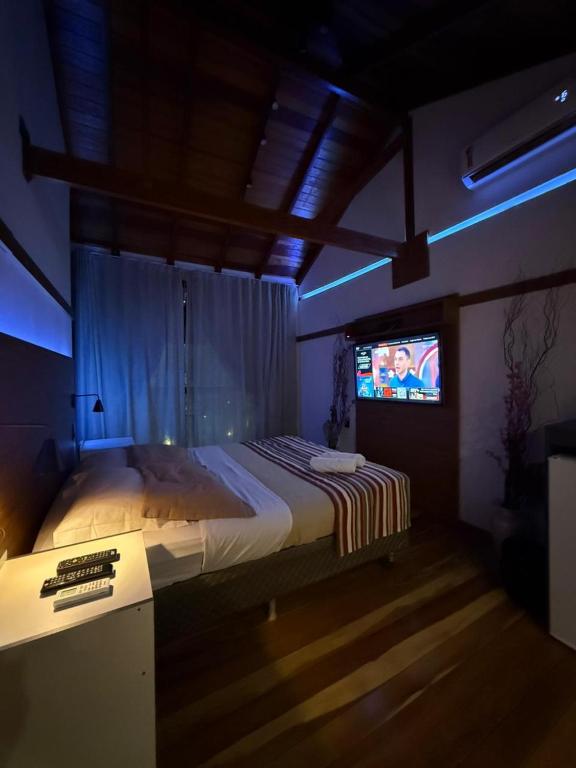 a bedroom with a bed and a tv in it at Deck1920 by Estadias Incríveis in Cascavel