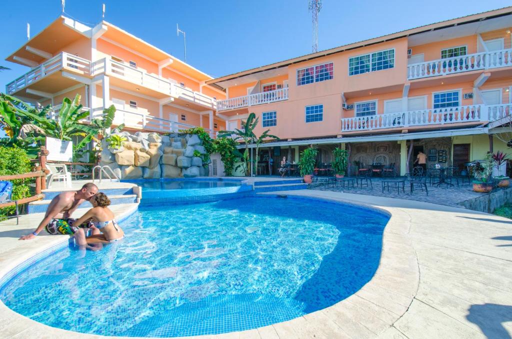 a man and a child in a swimming pool at a hotel at Cahal Pech Village Resort in San Ignacio