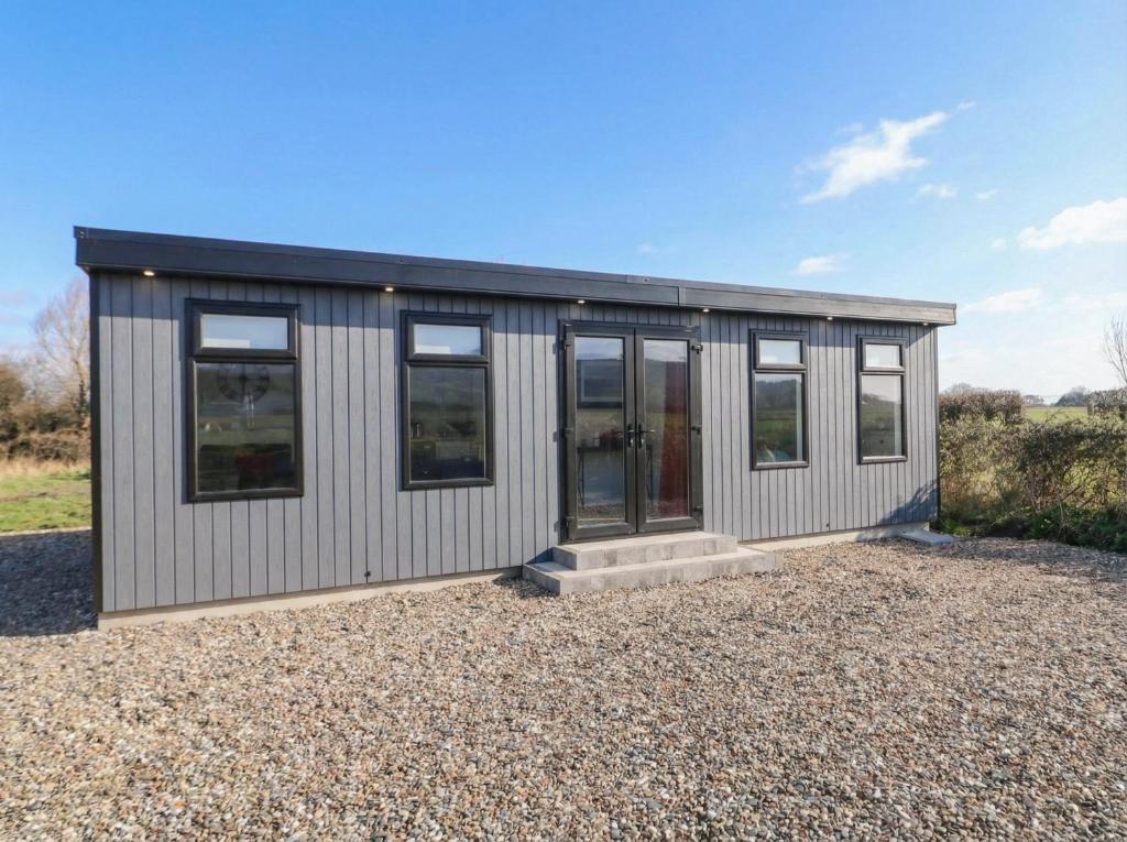 a small house with a black roof and windows at Binevenagh Point Cabin in Limavady