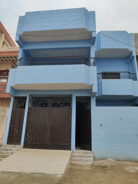 a blue building with two doors and a balcony at Dream Hostel Sukkur in Sukkur