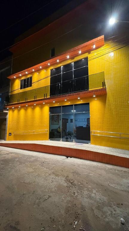 a yellow building with a large window on a street at Pousada Rafael in Juazeiro do Norte