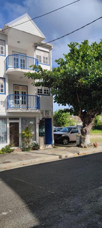 a house with a car parked in front of it at Cocon Alizé - Studio cozy, Port-Louis centre, plage à 10 min à pied in Port-Louis