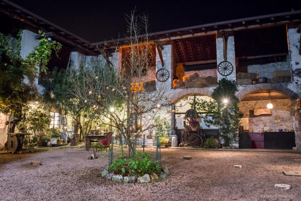 un bâtiment avec un arbre dans une cour la nuit dans l'établissement Corte dei Brut, à Gavirate