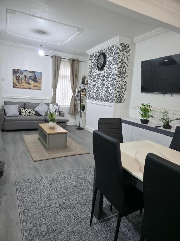 a living room with a couch and a table at Costa Home - 3 bed house with free on-street parking - ideal for workers in Middlesbrough