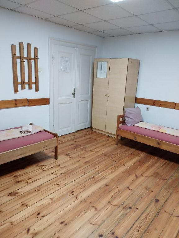 a room with two beds and a wooden floor at Скай Румс -3 in Sofia