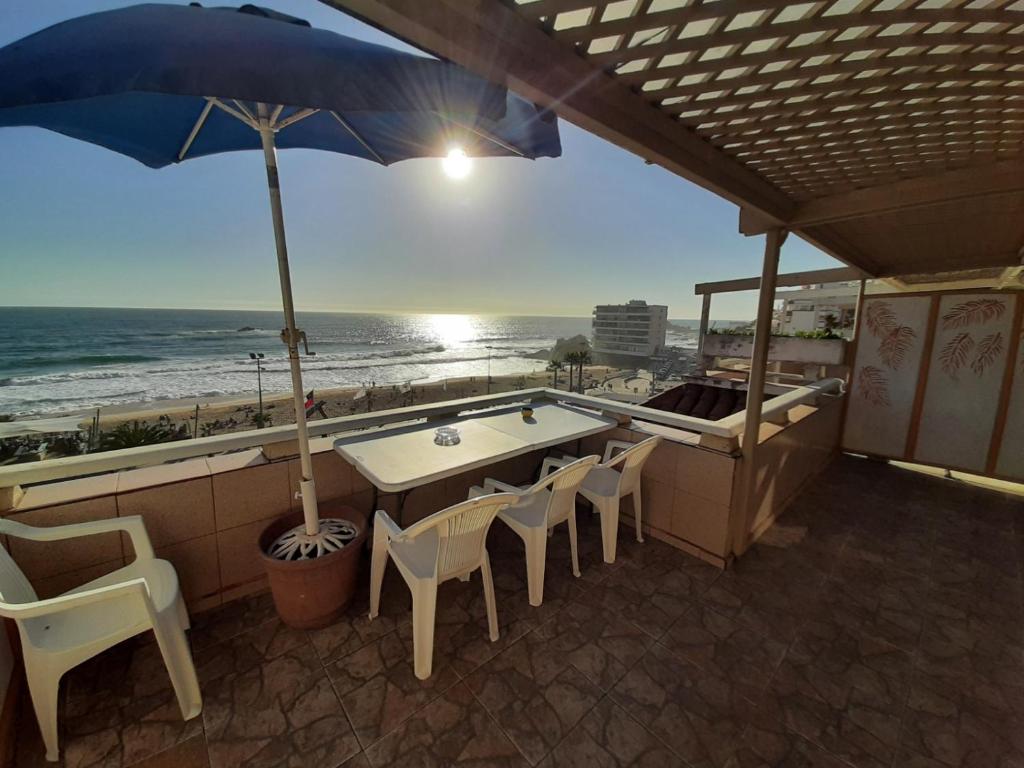 a table and chairs with a view of the beach at Reñaca - Primera linea de playa con gran terraza in Viña del Mar