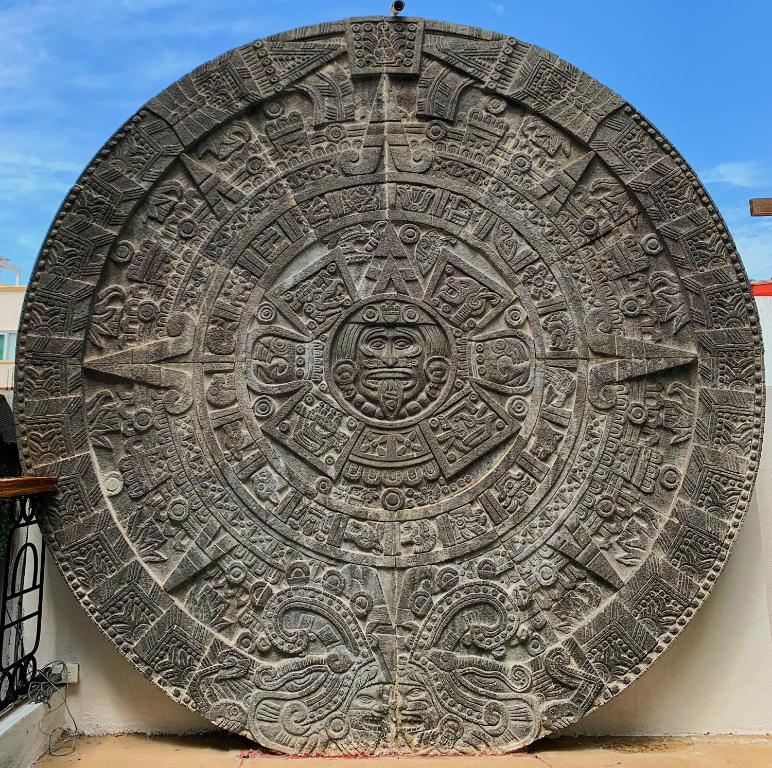 a large metal artifact on the side of a building at Casa calendario azteca in Playa del Carmen