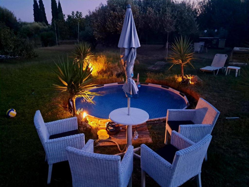 a table with an umbrella and chairs next to a pool at Enjoy The Silence in Svoronata