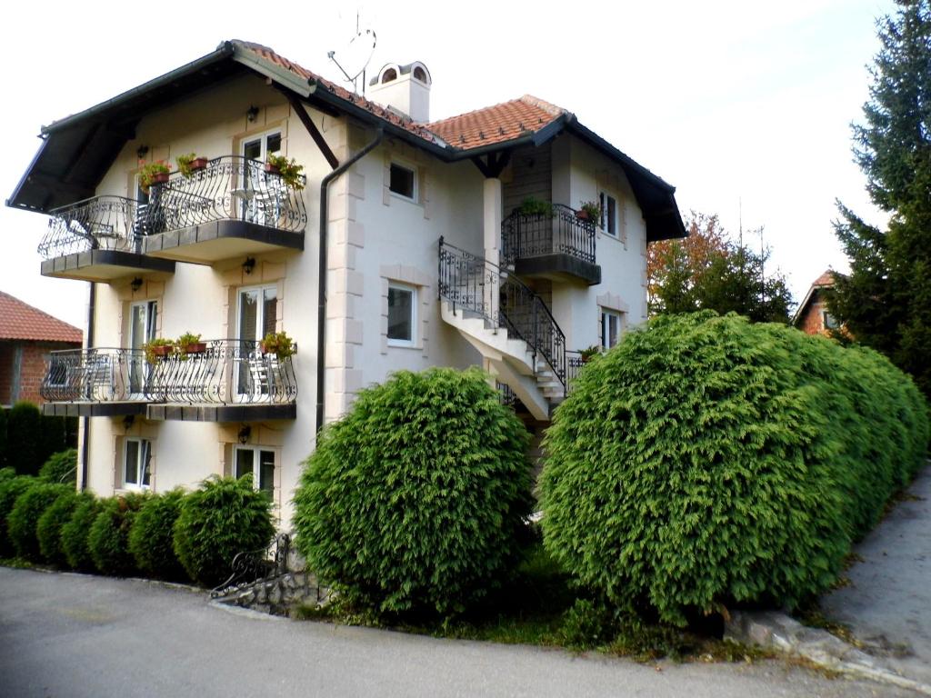 un edificio blanco con balcones y arbustos en Villa Dama & Dubravka, en Zlatibor