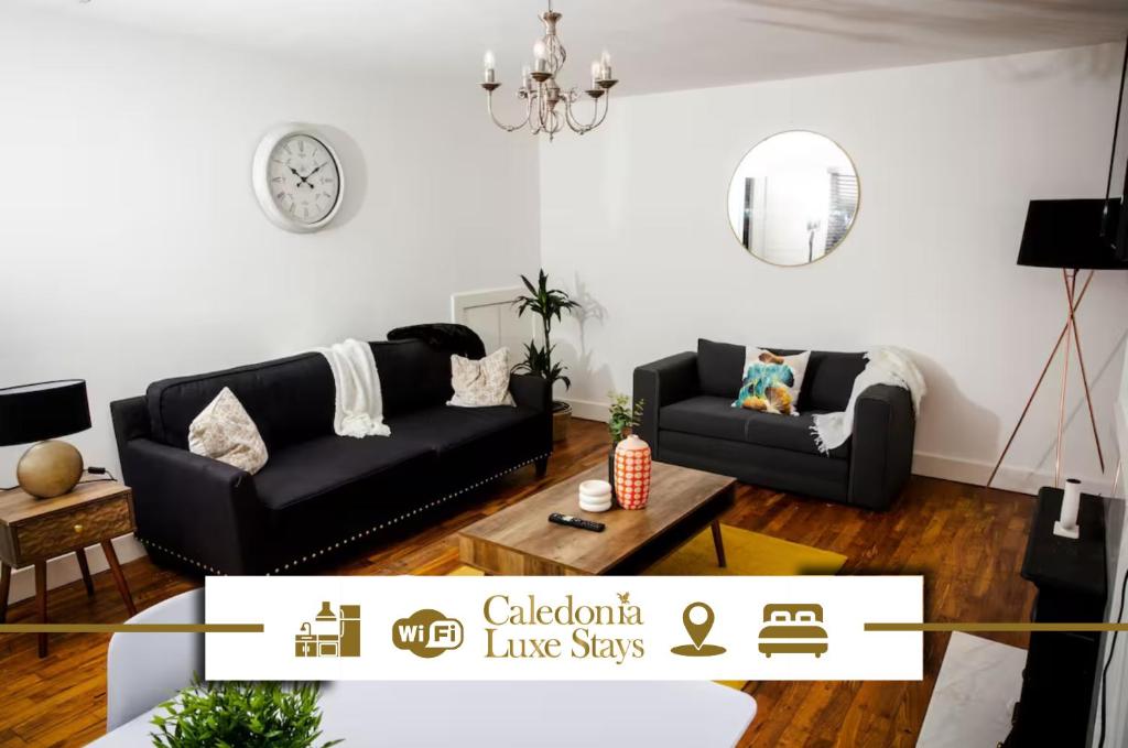 a living room with a black couch and a table at Tower Square House in Alloa