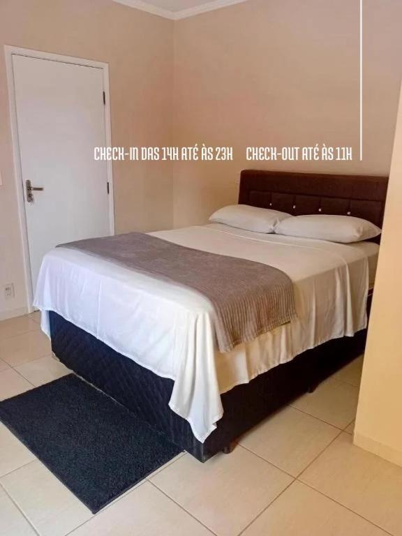 a bedroom with a bed with a sign on the wall at Casal Suíte Privativa com Sacada in Sao Jose do Rio Preto