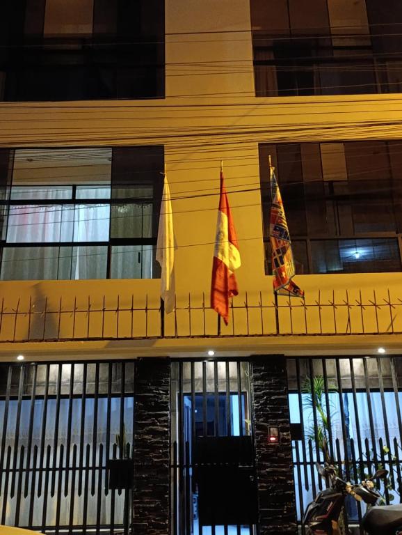 two flags hanging on the side of a building at Hospedaje Dajoka's in Lima