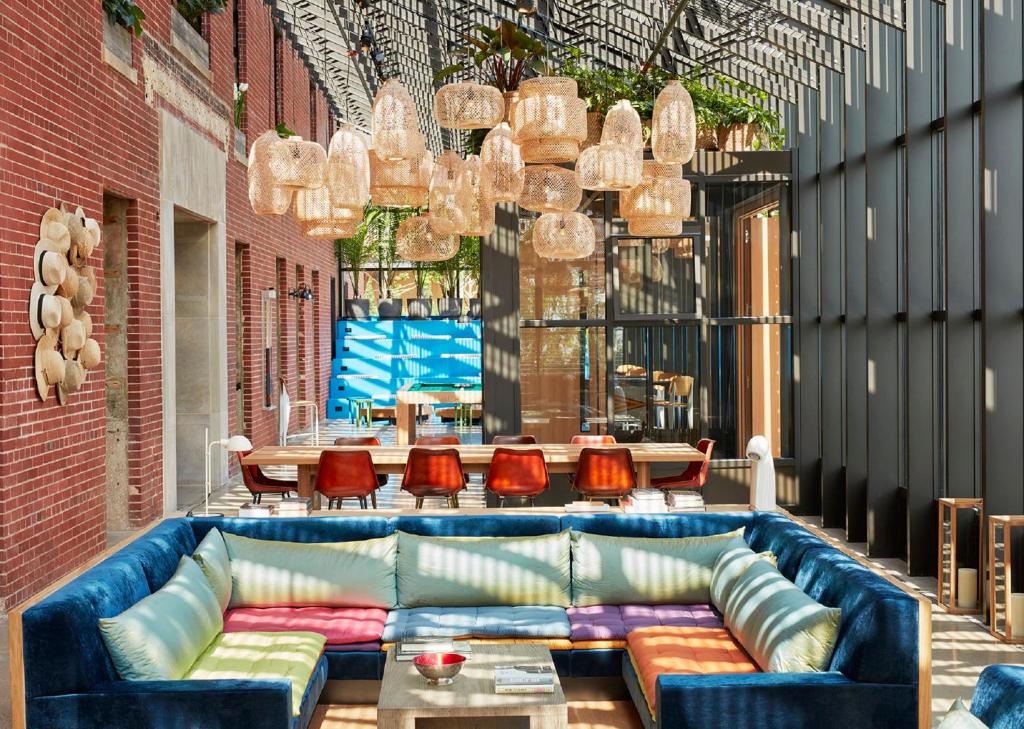 a living room with a blue couch and chairs at The Asbury Hotel in Asbury Park