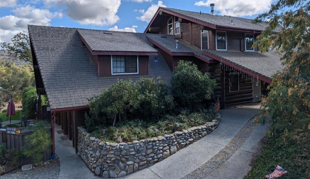 a house with a stone retaining wall in front of it at Nature's Inn Bed and Breakfast in Ahwahnee