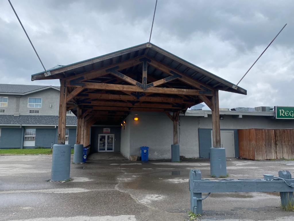 a building with a wooden pavilion in a parking lot at Burntwood Hotel and Restaurant in Thompson